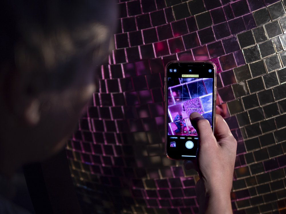 scanning a QR CODE at the pink section of the bright future installation by momantai studio.